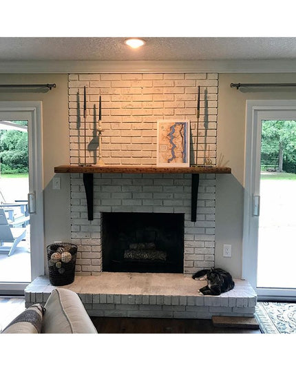 Black metal Syracuse countertop support brackets holding dark wood mantel above brick fireplace by Industrial Farm Co