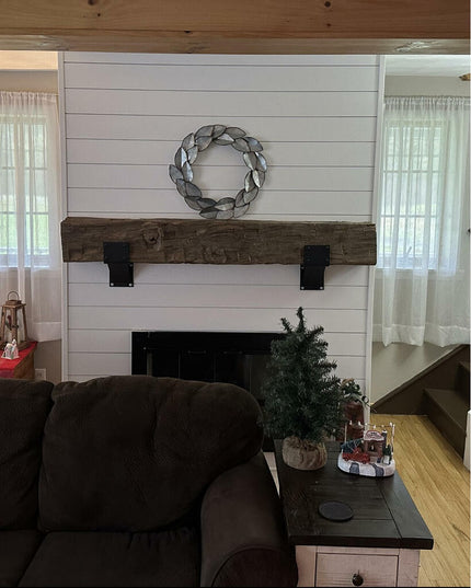 Heavy duty black steel Mottville 5" mantel brackets with rivets supporting rustic wood beam mantel on white shiplap firepl...