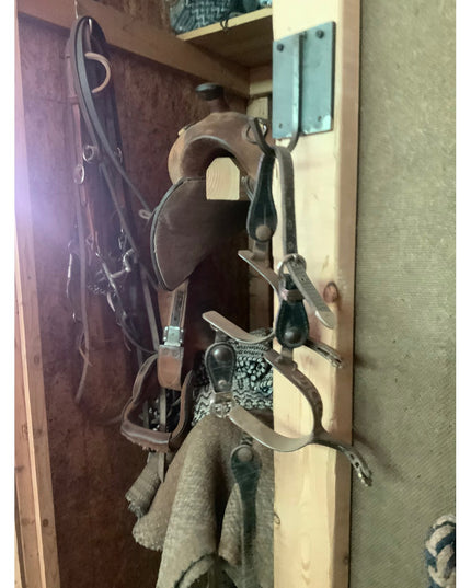 Industrial Farm Co Marcellus black metal wall hook mounted on wooden beam holding horse bridles and rope equipment in rust...