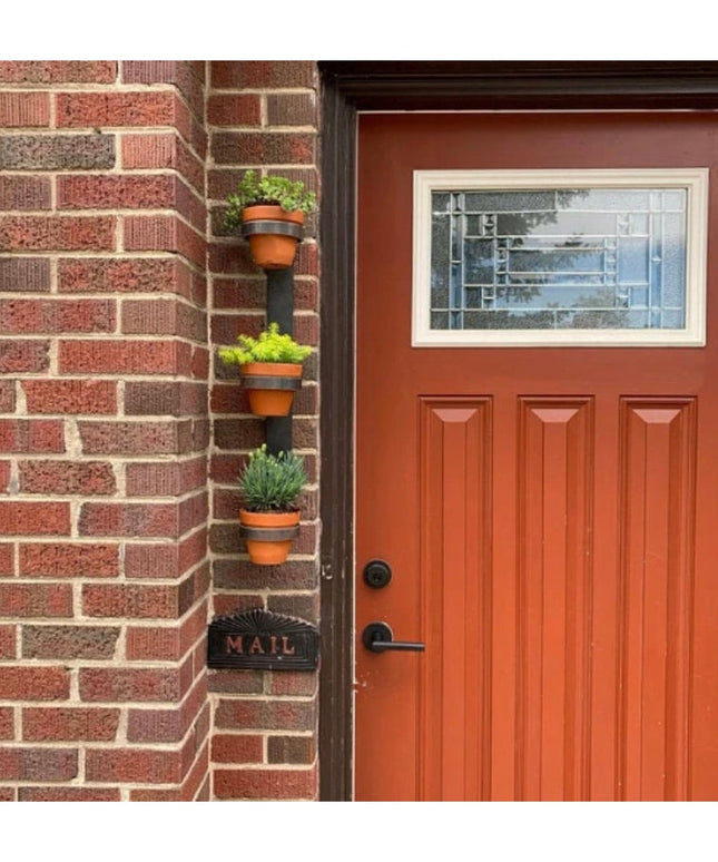 Industrial Farm Co Watertown black metal wall mount vertical planter with terracotta pots displaying herbs on brick exteri...