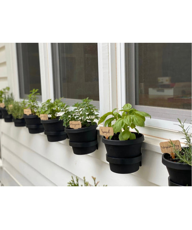 Black fabric Smoral Handmade Pot Holders by Industrial Farm Co displaying potted herbs with wooden plant labels on white w...
