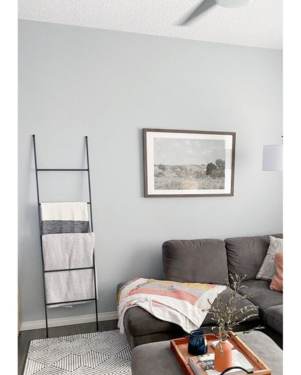 Black metal decorative ladder with blankets draped on rungs in modern living room - The Lynn Metal Ladder by Industrial Fa...