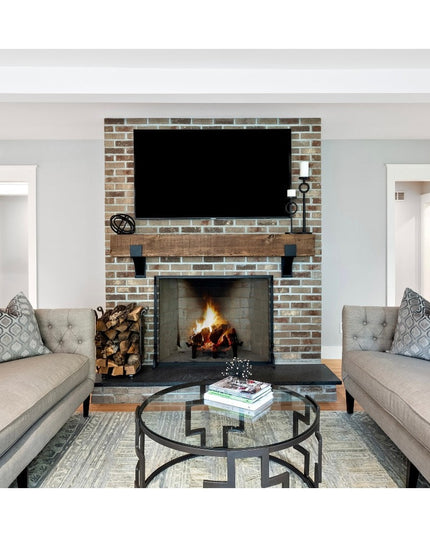 Rustic wood Kudlick Farmhouse Mantel Brackets supporting wooden beam above brick fireplace in modern living room with gray...