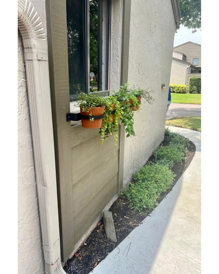 Yonkers Horizontal Steel Planter by Industrial Farm Co mounted on wooden post holding terracotta pots with trailing plants
