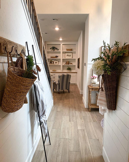 Black metal decorative ladder The Lynn from Industrial Farm Co displayed in farmhouse hallway with wicker baskets and whit...