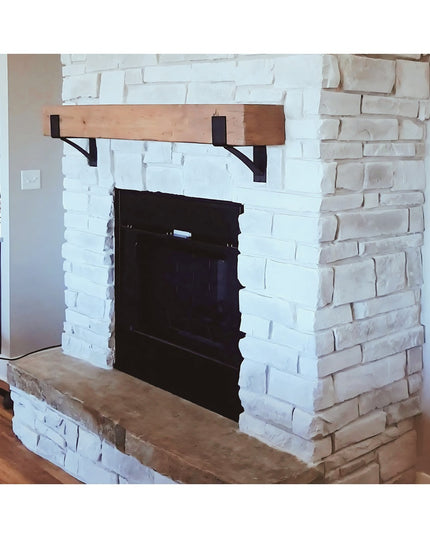 Rustic wood mantel with black metal Seneca 3" Farmhouse Brackets mounted on white painted brick fireplace by Industrial Fa...