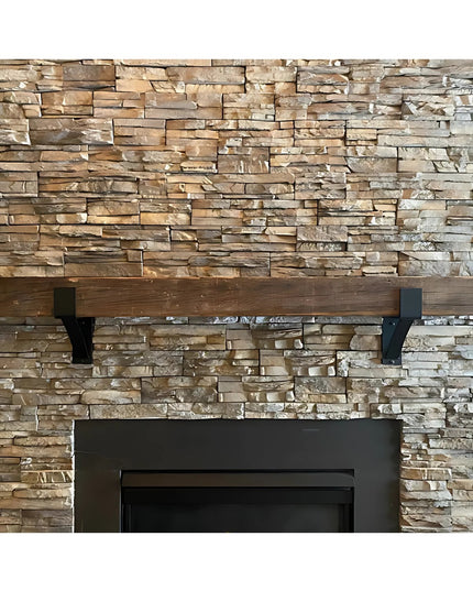 The Seneca 3" black metal farmhouse mantel bracket supporting wooden shelf against stacked stone fireplace wall by Industr...