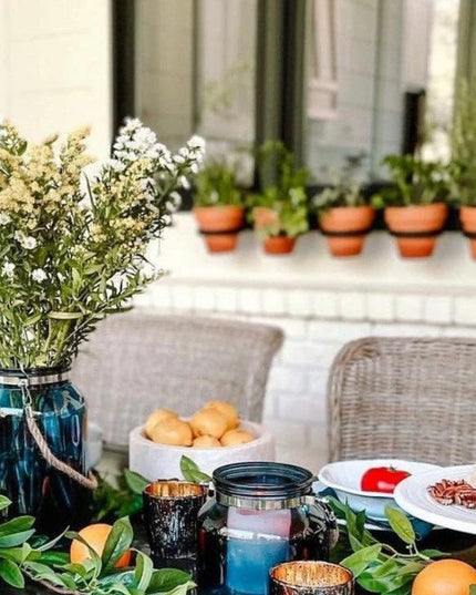 Black steel horizontal planter from Industrial Farm Co displayed on outdoor patio table with terra cotta pots and fresh fl...