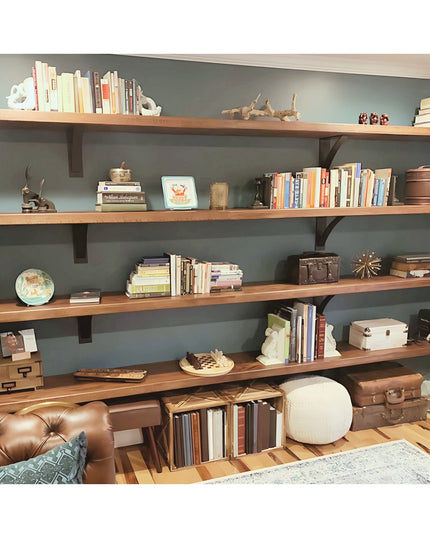 Industrial Farm Co Dibbles 3" black steel shelf brackets supporting wooden shelves with books and decor in modern living room