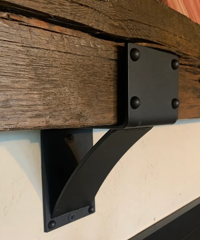 Heavy duty black steel Mottville 5" mantel bracket with decorative rivets mounted under rustic wooden beam by Industrial F...