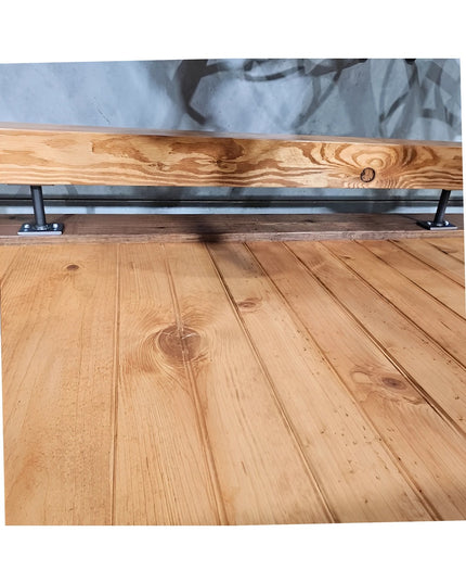 Black metal bar foot rail brackets mounted on natural wood rail against light blue wall with rustic wood plank flooring - ...