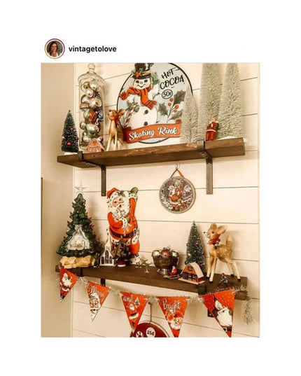 Rustic wooden shelves with black metal Z-style brackets displaying vintage Christmas decorations including snowman sign, S...