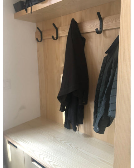 Black metal Henrietta 1" Wide Double Hooks by Industrial Farm Co mounted on light wood entryway storage unit with dark clo...