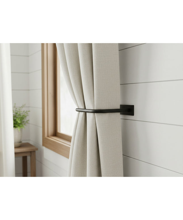 Black metal horse head curtain tie back holding beige linen curtains against white shiplap wall by Industrial Farm Co