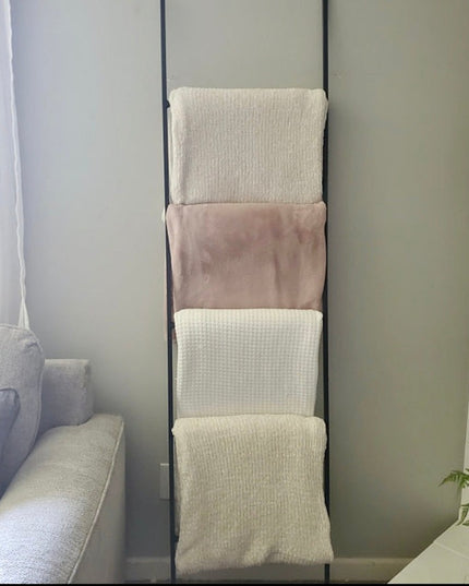 Lynn Metal Ladder by Industrial Farm Co with black frame displaying neutral blankets and throws in modern living room setting