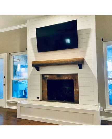 Black steel Eleanor Minimal brackets supporting wooden mantel shelf above white shiplap fireplace by Industrial Farm Co