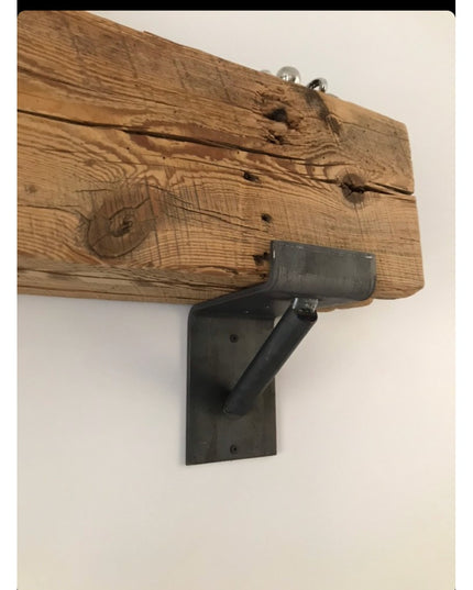 Rustic reclaimed wood beam with black metal Industrial Farm Co Shaver Open Shelving Support bracket mounted on white wall