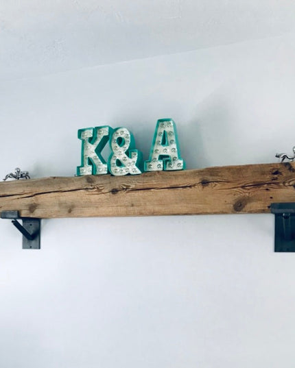 Industrial rustic wood wall shelf with black metal brackets displaying teal marquee letters K&A and decorative metal ants,...