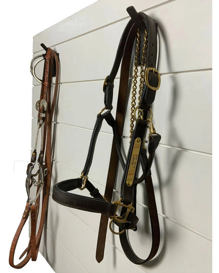 Black metal Tator Wall Mounted Hook by Industrial Farm Co displaying horse bridles and leather tack on white shiplap wall