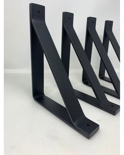 Four black metal Joyce Modern Shelf Support brackets by Industrial Farm Co arranged in descending size order, featuring cu...