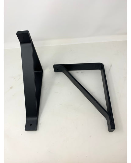 Two black metal Joyce Modern Shelf Support brackets by Industrial Farm Co with triangular reinforcement design on white ba...