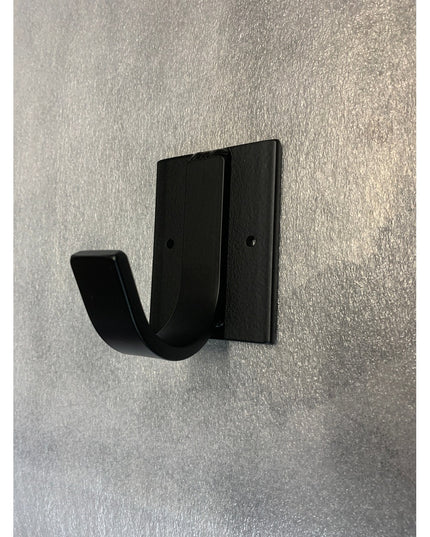 Black metal Dublin Mudroom Hook by Industrial Farm Co mounted on textured white wall, featuring curved design with rectang...
