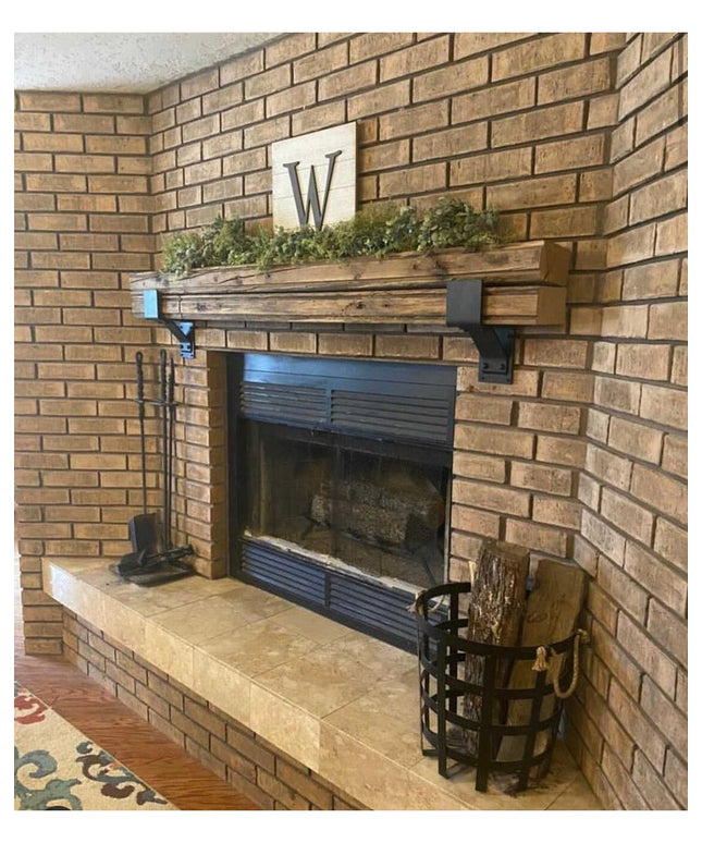 Rustic wooden mantel with black Monroe Style Corbel Brackets by Industrial Farm Co mounted on brick fireplace corner