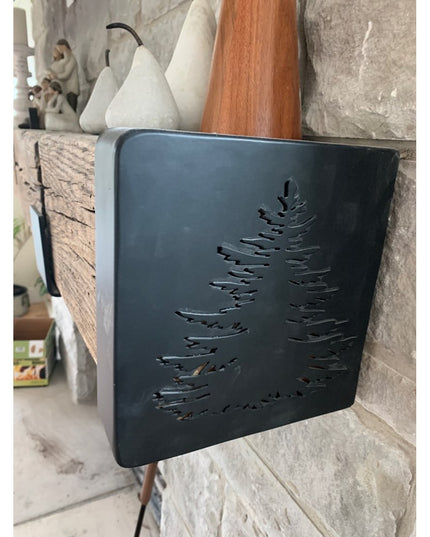 Black metal Vandiver Evergreen Tree Mantel End Caps with cutout pine tree design displayed on rustic stone fireplace mante...