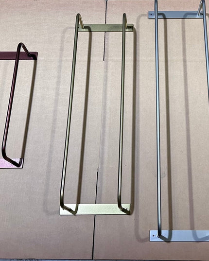 Three Tyler Bathroom Towel Racks by Industrial Farm Co in different colored metal finishes - burgundy, olive green, and si...