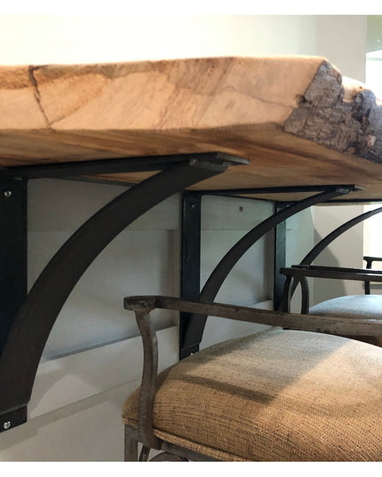 Black metal Lexica 4 inch wide shelf brackets supporting live edge wood countertop with upholstered chairs underneath from...