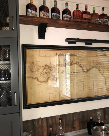 Black metal Industrial Farm Co Lexica 4 inch wide shelf supports holding rustic wood shelves with bourbon bottles in home bar