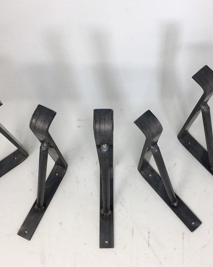 Five black metal Norwich Support Brackets by Industrial Farm Co arranged on white surface, showing triangular design with ...