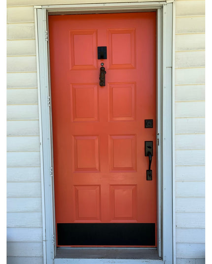 Rustic bronze Dublin Mudroom Hook by Industrial Farm Co mounted on coral orange front door with white clapboard siding