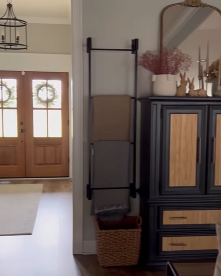 Home interior with wooden cabinet, mirror, and decor items on a smartphone screen.