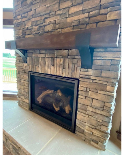 Otisco Farmhouse style wooden bracket supporting stone fireplace mantel with rustic wood beam and stacked stone surround b...