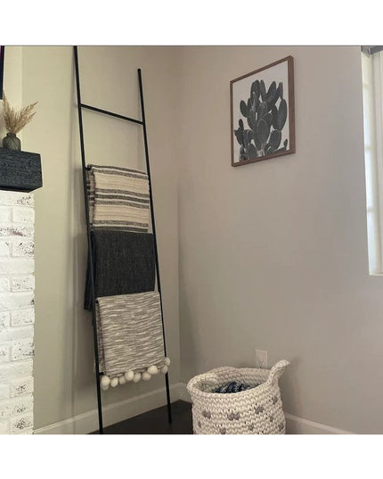 The Lynn Metal Ladder by Industrial Farm Co displaying woven blankets in modern living room corner with basket and cactus ...