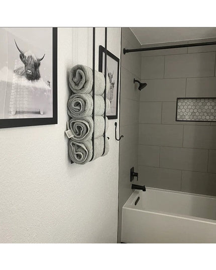 Black metal Tyler Bathroom Towel Rack by Industrial Farm Co mounted on white wall holding rolled gray towels next to moder...