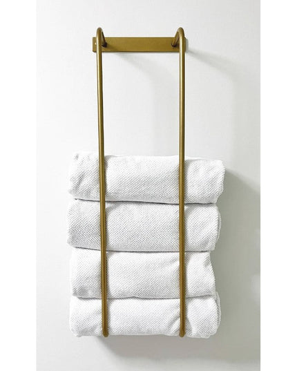 Industrial Farm Co Tyler Bathroom Towel Rack in brass gold finish mounted on white wall holding four folded white towels