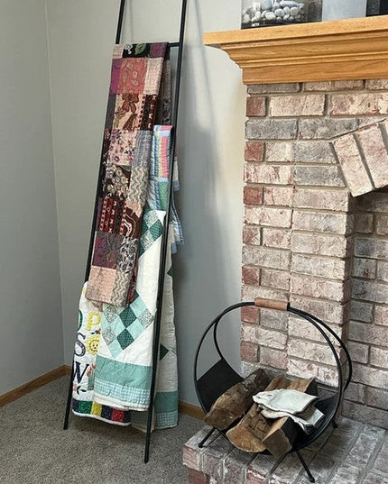 Black metal ladder displaying colorful quilts next to brick fireplace - The Lynn Metal Ladder by Industrial Farm Co