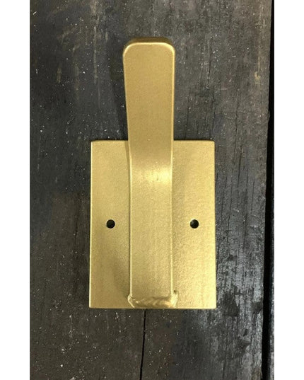 The Tator Wall Mounted Hook by Industrial Farm Co in gold brass finish with geometric design and two mounting holes on dar...