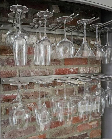 White Plains Wine Glass Rack by Industrial Farm Co displaying clear wine glasses hanging upside down in rustic brick cabin...
