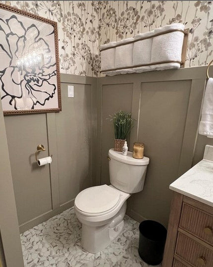 Gold brass Tyler bathroom towel rack mounted on wall in elegant powder room with floral wallpaper and gray wainscoting by ...