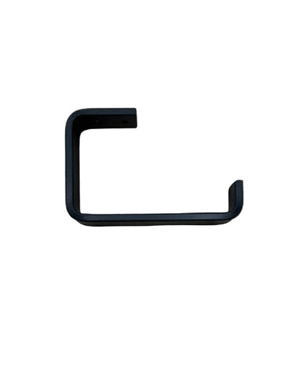 Black minimalist toilet paper holder from Industrial Farm Co mounted on light wood grain wall showing clean geometric L-sh...
