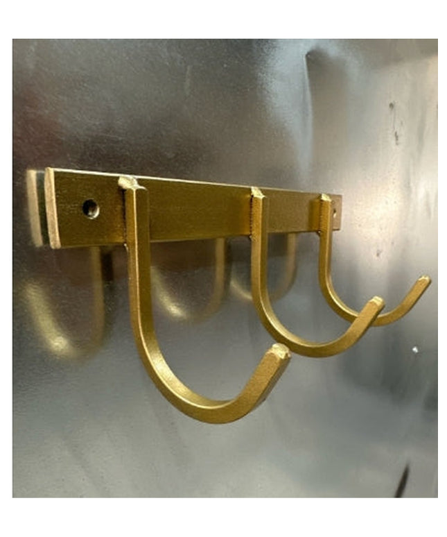 Gold metal wall-mounted key rack with 4 U-shaped hooks by Industrial Farm Co, showing modern rustic design on concrete wall