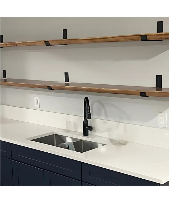 Black metal J-style shelf brackets supporting natural wood shelves in modern kitchen with navy cabinets and white countertops