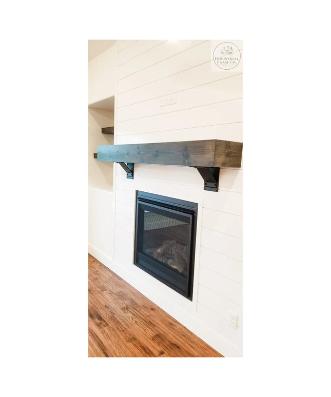 Rustic wood beam mantel with dark stained Geneseo Bracket Supports mounted on white shiplap wall above modern fireplace