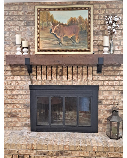 Black metal Seneca 3" Farmhouse Mantel Bracket by Industrial Farm Co supporting rustic wood mantel on brick fireplace