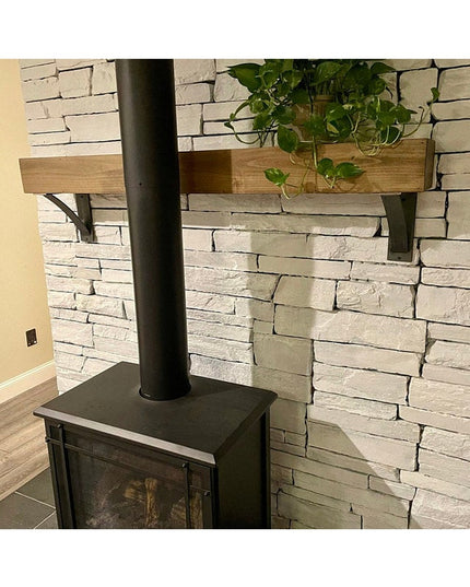 Heavy duty black steel Dibbles 3" industrial shelf brackets with curved support bar holding wooden shelf against white sto...