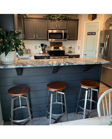 Steel industrial brackets supporting granite kitchen island countertop with navy blue shiplap base and bar stools - The El...