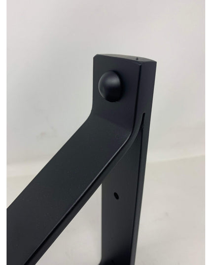 Black metal Joyce Modern Shelf Support bracket by Industrial Farm Co showing curved design and mounting holes against whit...